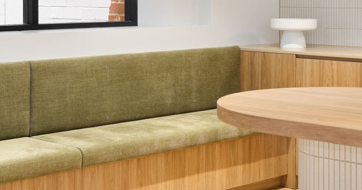 A green upholstered banquette in a commercial fit-out